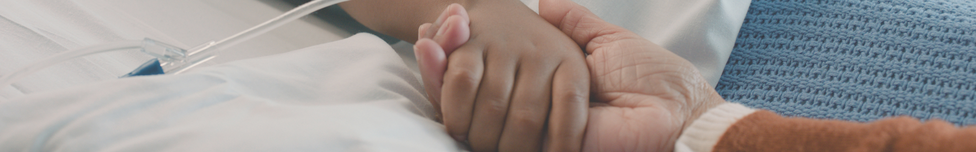 Banner image showing Two hands holding on top of a hospital bed
