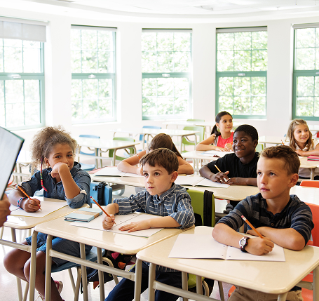 students sitting at a desk in their classroom