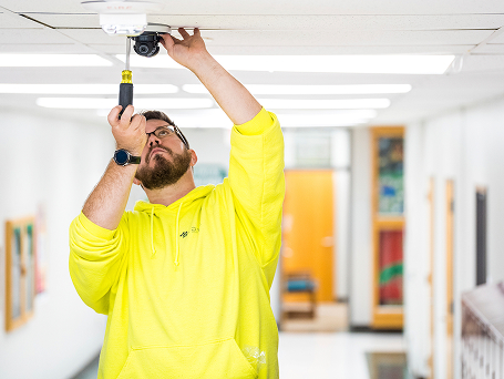 digi employee installing layered school security.