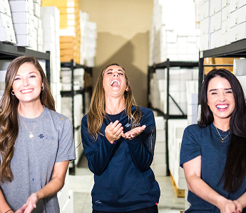 Three women employees at Digi are smiling at the camera.