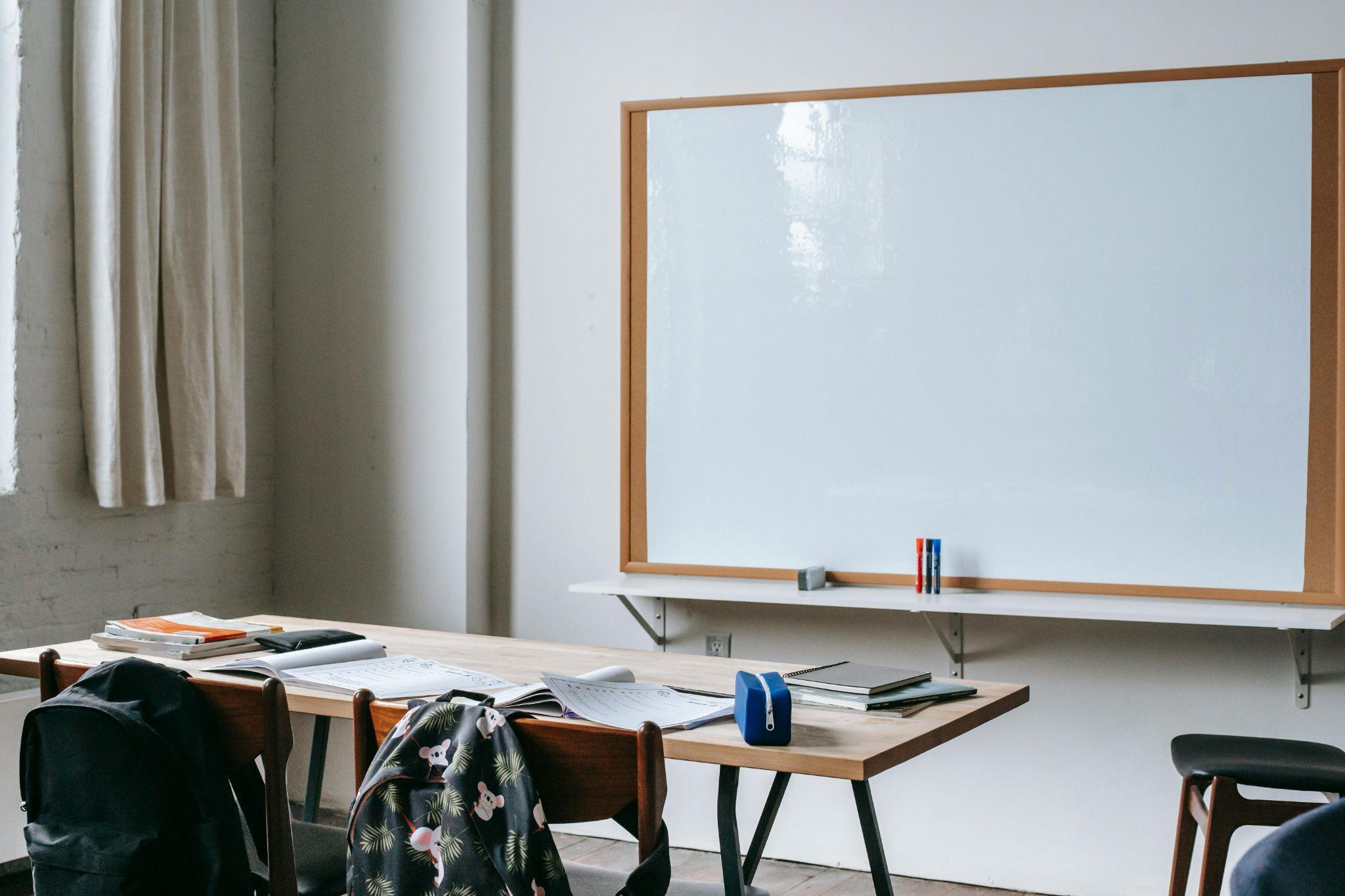 A classroom with stationery on the bench.