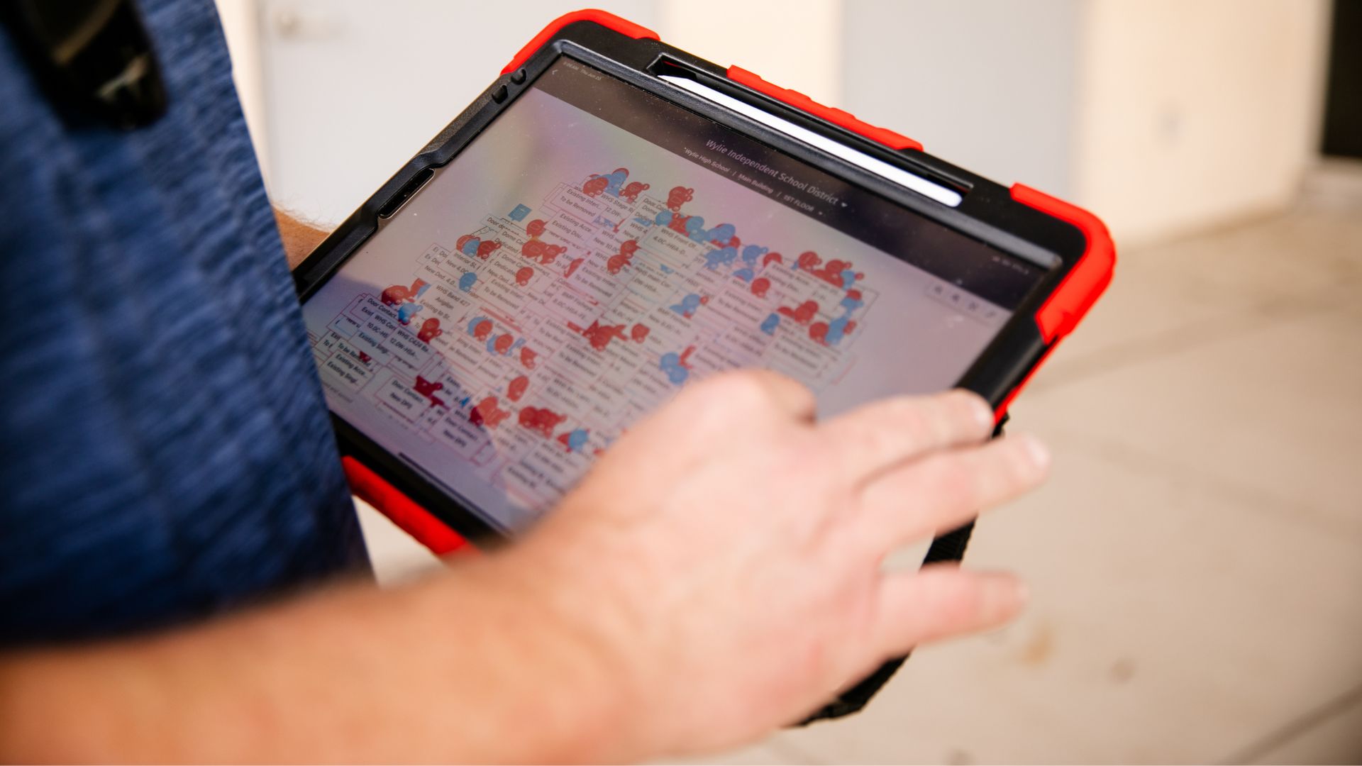 Digi security technician reviewing school access control floor plan on rugged tablet