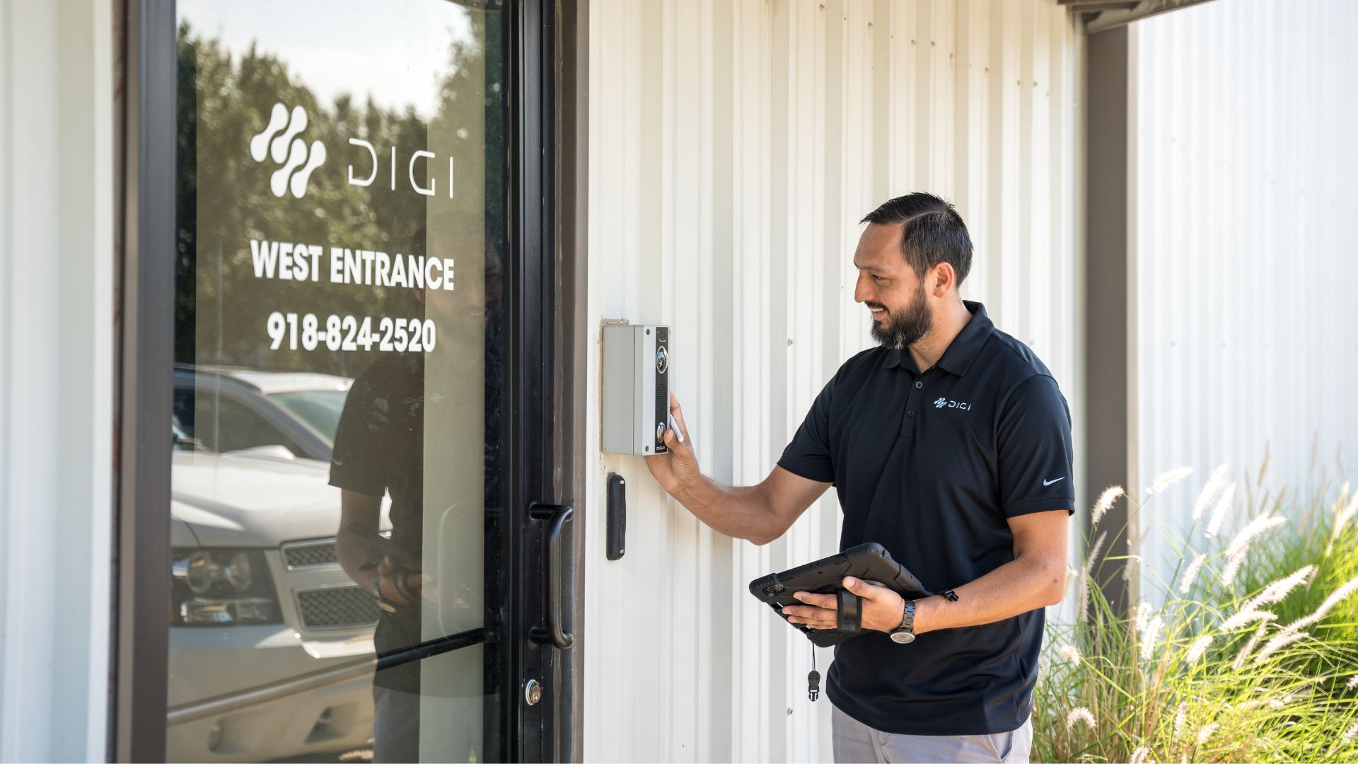 Digi Security Systems technician using access control keypad at building entrance
